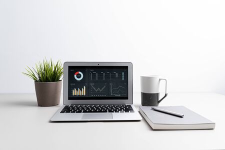 Laptop with  graph chart report screen on work table. Home office or work space. Strategy analysis financial accounting conceptの写真素材