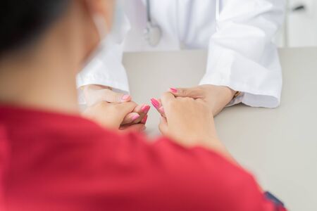 Hand of doctor reassuring her female patient. Asian peopleの写真素材