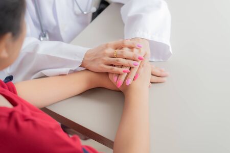 Hand of doctor reassuring her female patient. Asian peopleの写真素材