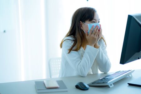 Asian woman using the medical face mask in officeの写真素材