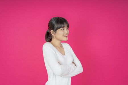 asian young casual style woman portrait isolated over pink background.の写真素材