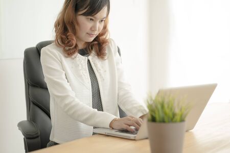 Asian business woman reviewing data in financial charts and graphs. Accountingの写真素材