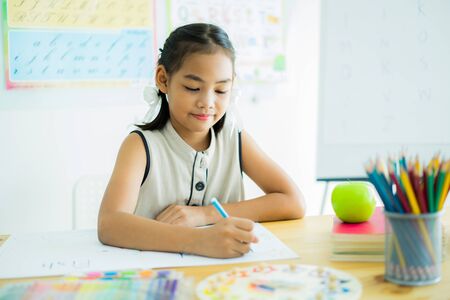 Asian cute little child girl drawing at homeの写真素材