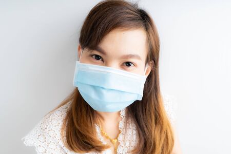Close up portrait of young woman with medicine health care mask against white white background. CoronaVirus, Covid-19. Asian peopleの写真素材