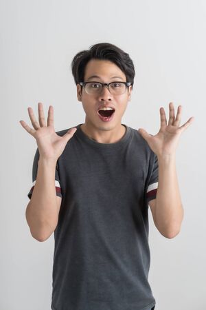 Do not miss. Young asian man shouting. Shout. Crying emotional man screaming on pink studio background. man half-length portrait. man emotions, facial expression concept. Trendyの写真素材