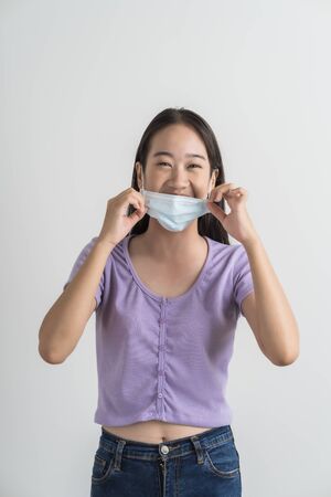 Close up portrait of young woman with medicine health care mask against white white background. CoronaVirus, Covid-19. Asian peopleの写真素材