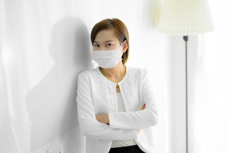 Asian woman using the medical face mask in officeの写真素材