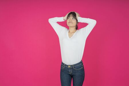 asian young casual style woman portrait isolated over pink background.の写真素材