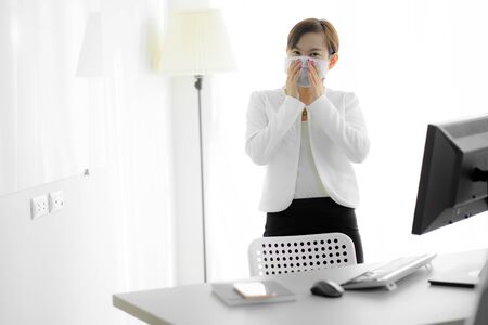 Asian woman using the medical face mask in officeの写真素材