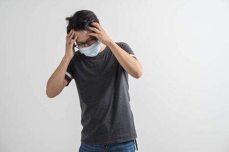 Portrait of young man with medicine health care mask against white gray background. Asian peopleの写真素材