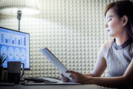 Asian business woman reviewing data in financial charts and graphs. Accountingの写真素材