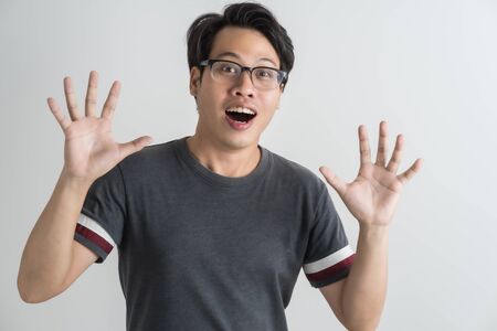 Do not miss. Young asian man shouting. Shout. Crying emotional man screaming on pink studio background. man half-length portrait. man emotions, facial expression concept. Trendyの写真素材
