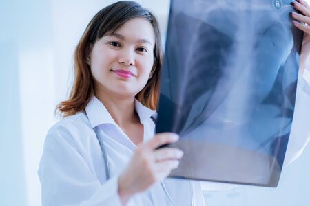 Asia Woman Doctor Looking at X-Ray Radiography in patient's Roomの写真素材
