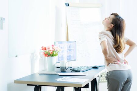 Business woman with back pain in office. Asian people. Work at home conceptの写真素材