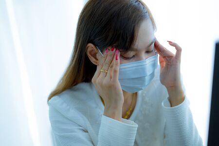 Asian woman using the medical face mask in officeの写真素材