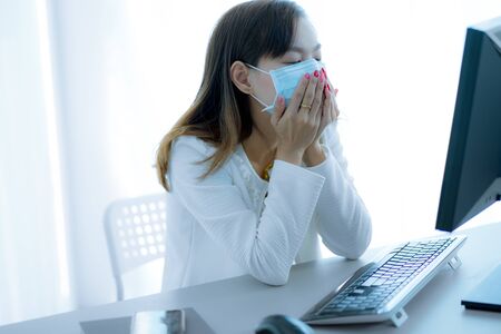 Asian woman using the medical face mask in officeの写真素材