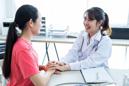 Hand of doctor reassuring her female patientの写真素材