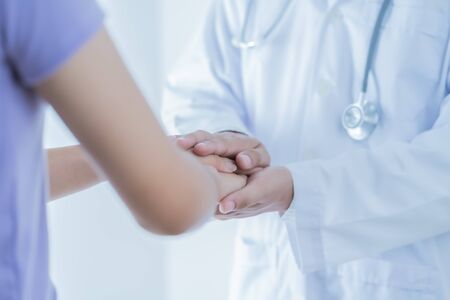 male doctor comforting patient at consulting room. Asian peopleの写真素材