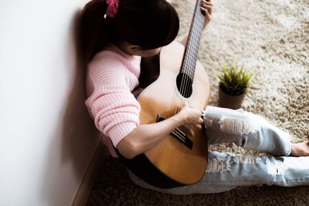 A beautiful asian woman playing acoustic guitarの写真素材
