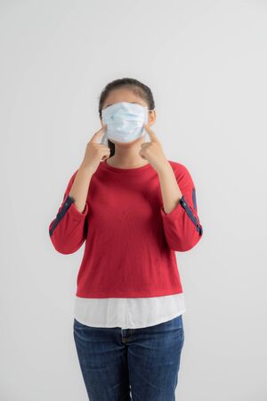 Close up portrait of young woman with medicine health care mask against white white background. CoronaVirus, Covid-19. Asian peopleの写真素材