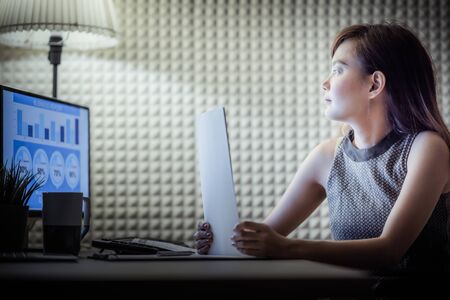 Asian business woman reviewing data in financial charts and graphs. Accountingの写真素材