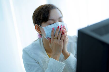 Asian woman using the medical face mask in officeの写真素材