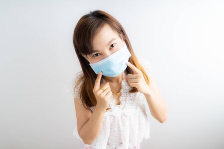 Close up portrait of young woman with medicine health care mask against white white background. CoronaVirus, Covid-19. Asian peopleの写真素材