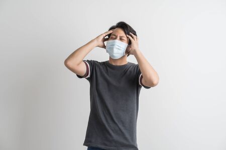 Portrait of young man with medicine health care mask against white gray background. Asian peopleの写真素材
