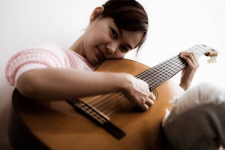 A beautiful asian woman playing acoustic guitarの写真素材