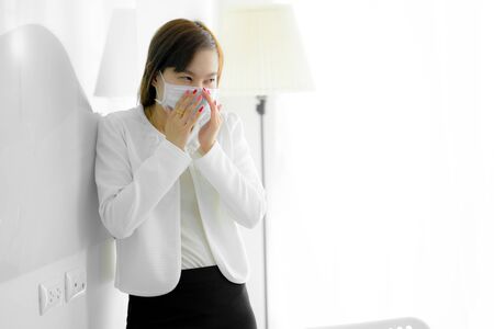 Asian woman using the medical face mask in officeの写真素材
