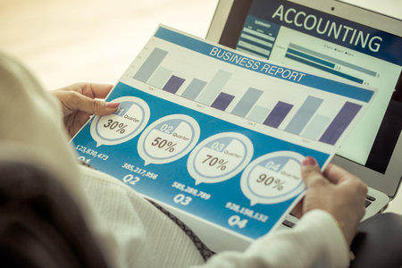 Asian business woman reviewing data in financial charts and graphs. Accountingの写真素材