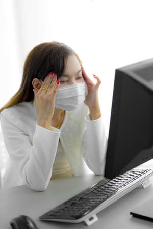 Asian woman using the medical face mask in officeの写真素材