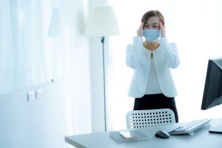 Asian woman using the medical face mask in officeの写真素材
