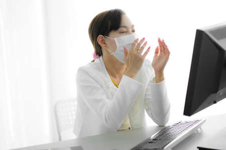 Asian woman using the medical face mask in officeの写真素材