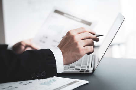 Businessman analyzing investment charts with laptop. Accounting conceptの写真素材