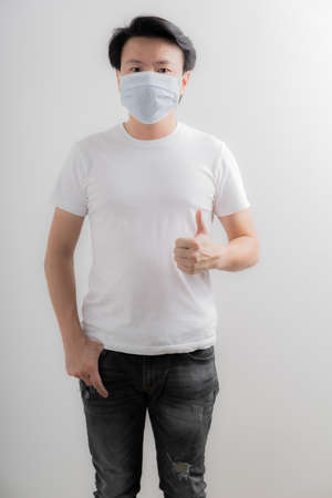 Portrait of young man with medicine health care mask against white gray background. Asian peopleの写真素材