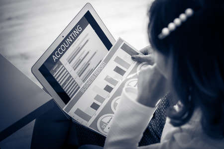 Asian business woman reviewing data in financial charts and graphs. Accountingの写真素材