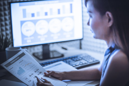 Asian business woman reviewing data in financial charts and graphs. Accountingの写真素材