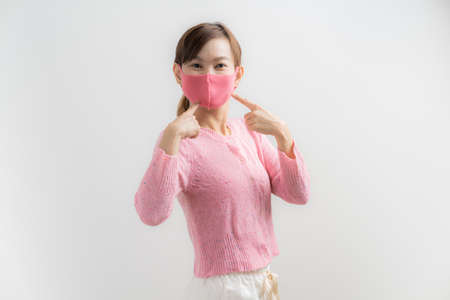 Close up portrait of young woman with medicine health care mask against white white background. CoronaVirus, Covid-19. Asian peopleの写真素材