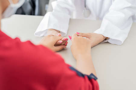 Hand of doctor reassuring her female patient. Asian peopleの写真素材