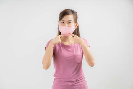 Close up portrait of young woman with medicine health care mask against white white background. CoronaVirus, Covid-19. Asian peopleの写真素材