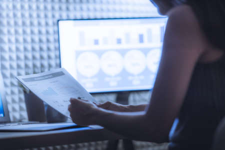 Asian business woman reviewing data in financial charts and graphs. Accountingの写真素材