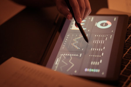 Asian business woman reviewing data in financial charts and graphs with tablet. Accountingの写真素材