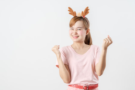 Asian woman is wearing christmas reindeer antlers over grey background.の写真素材