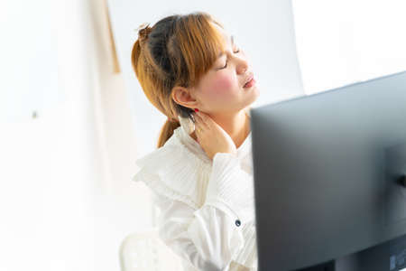 Business woman with back pain in office. Asian people. Work at home conceptの写真素材