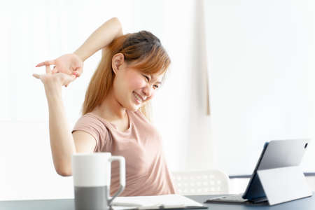 Young asian businesswoman feeling pain in neck after working on computer laptop for a long time. Office syndrome conceptの写真素材