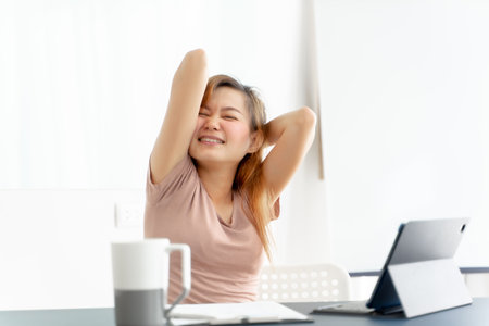 Young asian businesswoman feeling pain in neck after working on computer laptop for a long time. Office syndrome conceptの写真素材
