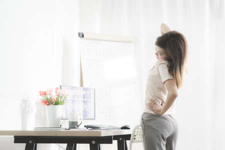 Business woman with back pain in office. Asian people. Work at home conceptの写真素材