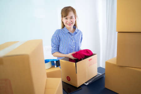 Entrepreneur owner receive and checking online purchase shopping order to preparing pack product box. Selling online ideas concept. Startup small businessの写真素材