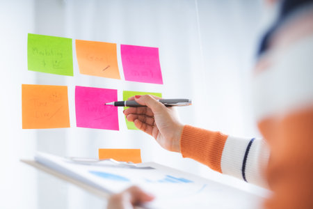 Business woman meeting at office and use  notes to share idea. Brainstorming concept. Sticky note on glass wall.の写真素材